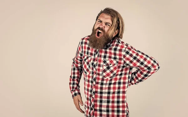 Homem barbudo brutal usar camisa quadriculada com barba exuberante e bigode sentir dor nas costas, medicina — Fotografia de Stock