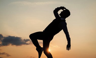 Güneşin doğuşunda özgürlüğe adım atan insan silüeti, başarı.