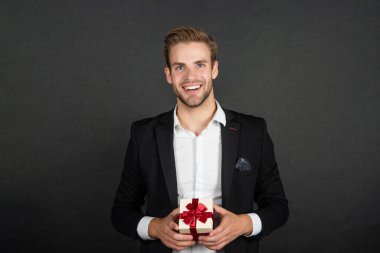 İş adamı kılığındaki neşeli, zarif adam sevgililer günü hediyesi tut, sevgilim ol.