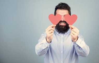 Yüreğiyle görebiliyor. Hippi gözlerini küçük kalplerle kapatıyor. Kırmızı kalp tutan sakallı adam. Aşk kartları olan seksi bir sevgililer günü erkeği. Sevgililer günün kutlu olsun. Aşkını ifade ediyor, kopyalama alanı