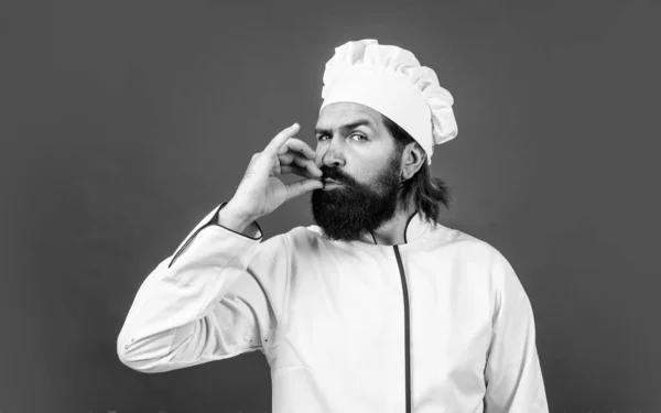 Впевнений шеф-кухар чоловік з бородою і вусами в кулінарній уніформі показує зіткнення досконалості, досконалий смак — стокове фото