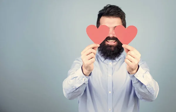 Ele consegue ver com o coração. Hipster cobrindo os olhos com corações pequenos. Homem barbudo com corações vermelhos. Homem valentine sexy com cartões de amor. Feliz Dia dos Namorados. Expressando seu amor, espaço de cópia — Fotografia de Stock