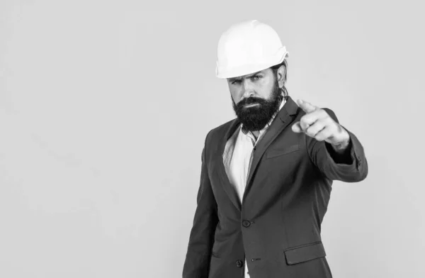 Seriózní muž s vousy nosí tvrdý klobouk ukazující prstem. inženýrství. architektura a budova. mužský stavitel ve formálním obleku a helmě na ochranu. pracuje na stavebním projektu. kopírovat prostor — Stock fotografie