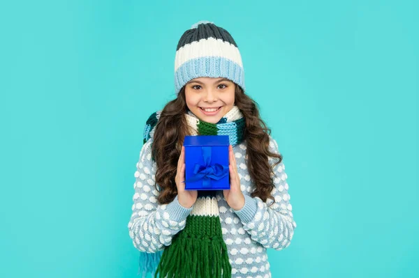 Enfant souriant dans la boîte de maintien tricot. Un enfant avec un cadeau. adolescent fille sur fond bleu. vacances d'hiver — Photo