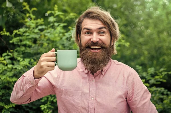 Homem barbudo a beber bebidas. hipster maduro com barba beber café. brutal caucasiano hipster segurar xícara de chá. manhã perfeita masculina. homem de negócios feliz na camisa com caneca — Fotografia de Stock