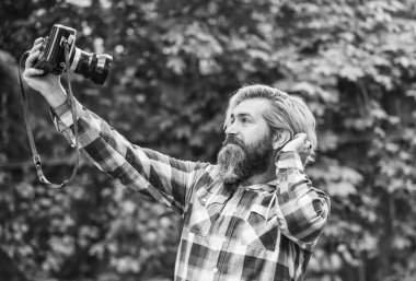Selfie zamanı. Klasik kamera. bu anıları yakala. SLR kamera. Sakallı hippi profesyonel kamera kullanıyor. Fotoğrafçı, retro kamerayı tut. Gazetecilik benim kariyerim. muhabir fotoğraf yaptı