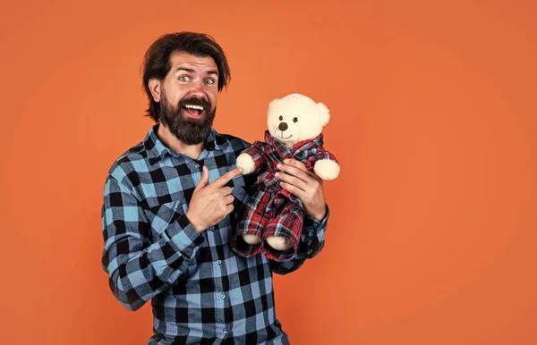 Жорстокий бородатий чоловік зі стильним виглядом грає з ведмедем, плюшевим ведмедем — стокове фото