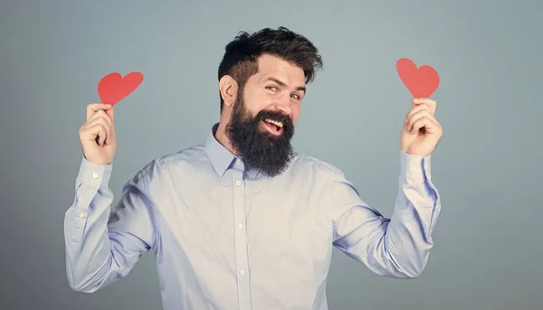 Sentir amor. Concepto de citas y relaciones. Feliz en el amor. Enamorarse. Un hipster barbudo con tarjeta de San Valentín. Celebra el amor. Chico atractivo con barba y bigote en estado de ánimo romántico — Foto de Stock