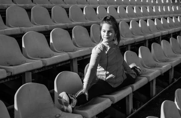 Adolescente menina sentar na divisão no estádio ao ar livre tribuno, ginasta — Fotografia de Stock