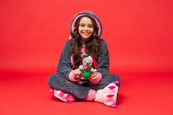 Gelukkig kind in gezellige slaapkledij met kerstspeelgoed. Slaap lekker. comfortabele pyjama — Stockfoto