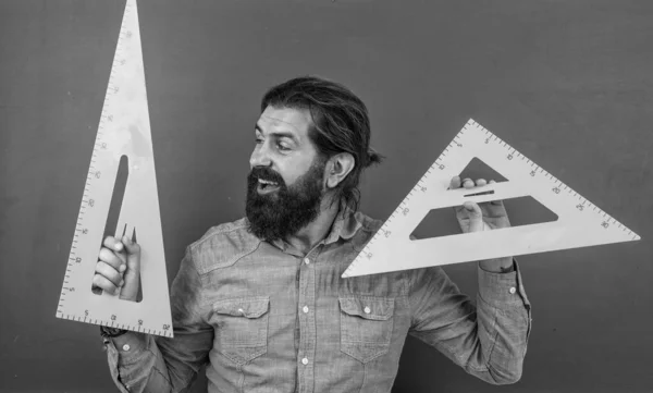 Взрослый бородатый учитель в классе с доской, геометрией — стоковое фото