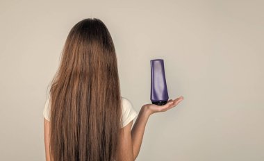 Çocuk kızın modaya uygun saç stili var ve şişede losyon kullan, kuaför.