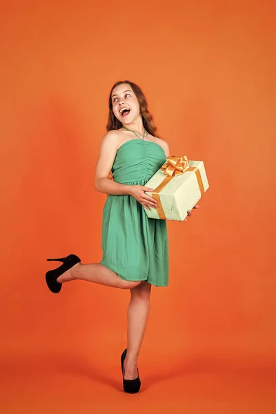 Niño feliz con caja de regalo sobre fondo naranja, lunes cibernético — Foto de Stock