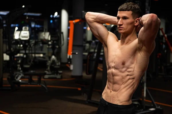 Muskulöser Mann, der die Arme hinter dem Nacken hält und Sixpack-Bauch im Fitnessstudio beugt, Oberkörper — Stockfoto
