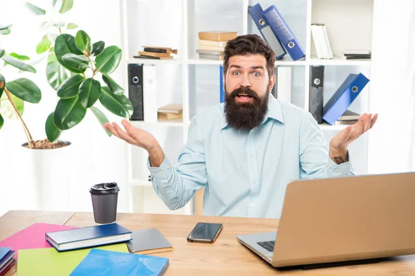 Περίεργος τύπος κάνει αβοήθητη χειρονομία δουλεύοντας στο γραφείο του γραφείου, αμηχανία — Φωτογραφία Αρχείου