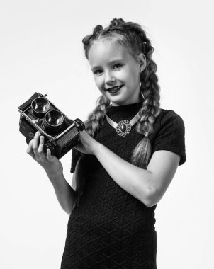 Retro kameralı şık çocuk beyaz teknolojiyle izole edilmiş fotoğraf yapıyor.