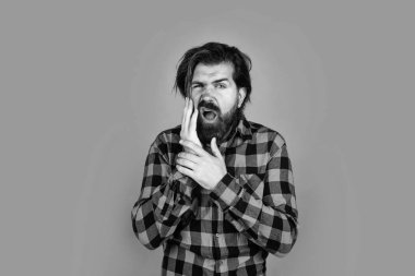 Acıyı hisset. Kareli gömlekli sakallı adam. Duygusal yüzlü acımasız bir adam. Mutsuz yakışıklı hipster 'ın dişi ağrıyor. Olgun adamın bıyığı var.