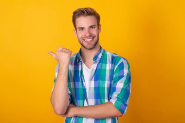 Buradaki ilanınız. Başparmak sarısı arka planı gösteren mutlu adam. İlanınızı yerleştirin, kopyalama alanı