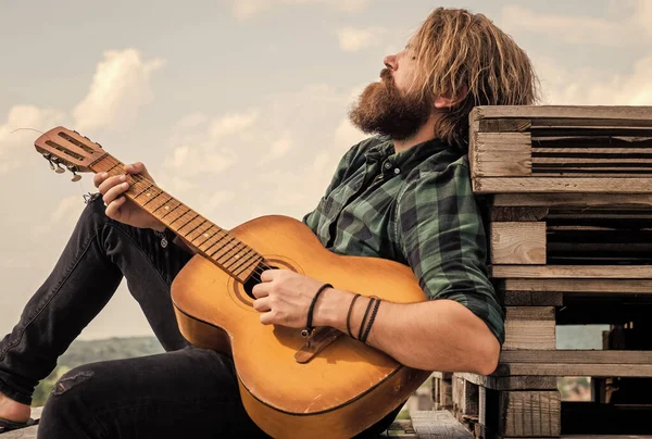 Hombre barbudo maduro buscando moda casual tocando la guitarra, relajarse. — Foto de Stock