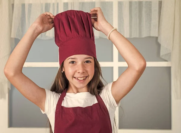 행복 한 아이들은 요리용 유니폼을 입습니다. 모자쓰고 앞치마입은 여자. 아이들은 부엌에서 요리를 합니다. 직업을 선택 한다. 부엌에 있는 작은 도우미. 요리와 요리. 행복 한 어린 시절 — 스톡 사진