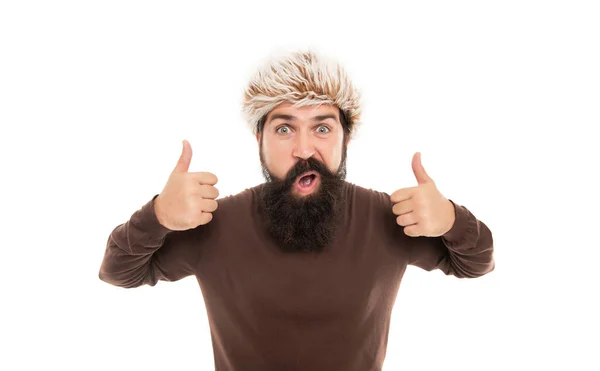 Homem barbudo surpreso com bigode em chapéu earflape mostrar polegar isolado em branco, moda. — Fotografia de Stock