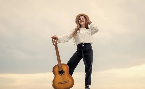 Heureux adolescent fille jouer guitare acoustique en plein air sur ciel arrière-plan, chanteur — Photo