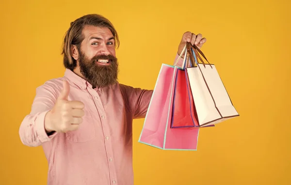 Жестокий бородатый мужчина держит подарок или подарок пакет, черная пятница — стоковое фото