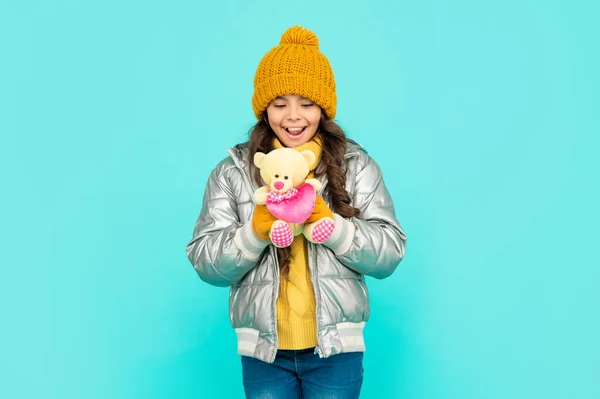 Enfant étonné dans le chapeau et la veste gonflante avec jouet sur fond bleu, Saint Valentin — Photo