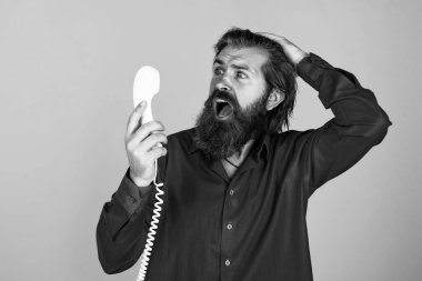 Olgun sakallı adam modaya uygun görünüyor. Retro telefonu tut, konuş.