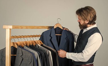 Sakallı adam kendine uygun bir kıyafet arıyor. Özel kıyafet konsepti.