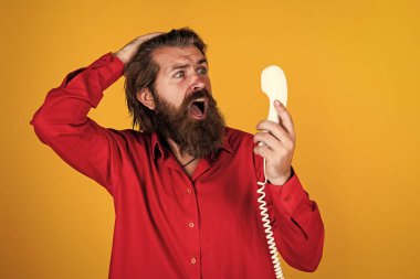 Olgun sakallı adam modaya uygun görünüyor. Retro telefonu tut, konuş.