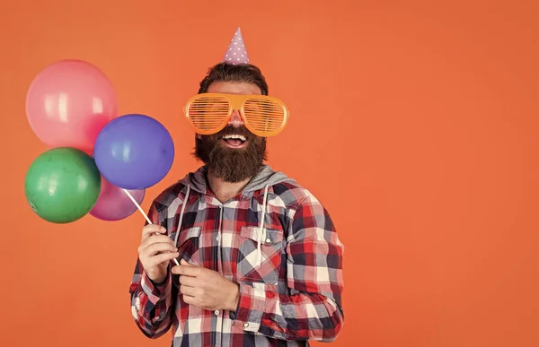 流行の髪型をしたスタイリッシュな髭男はチェックシャツを着てパーティー風船を保持します,記念日 — ストック写真