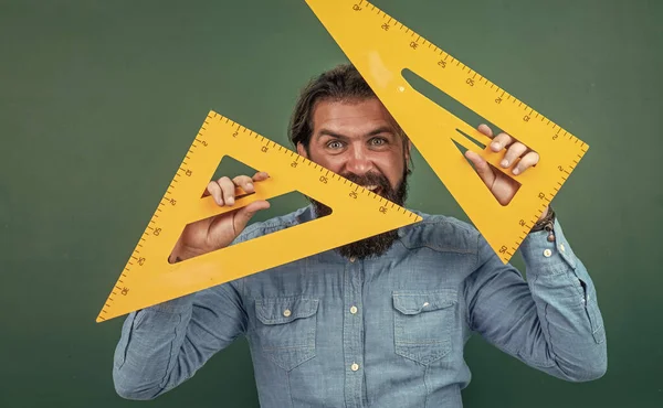 Homem com barba e bigode olhar como homem de negócios ou professor na faculdade ou escola, ferramenta triângulo — Fotografia de Stock