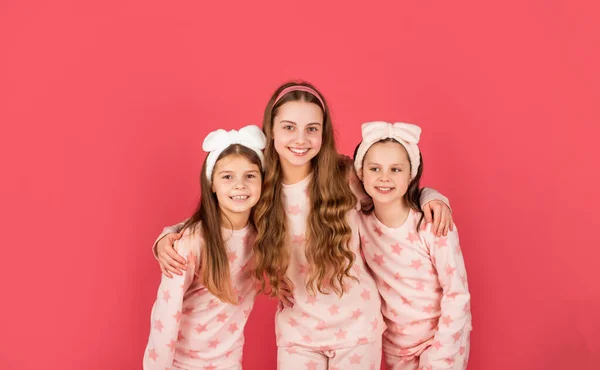 Odzież i piżama dla dziewcząt. Szczęśliwe siostry w homewear różowe tło — Zdjęcie stockowe
