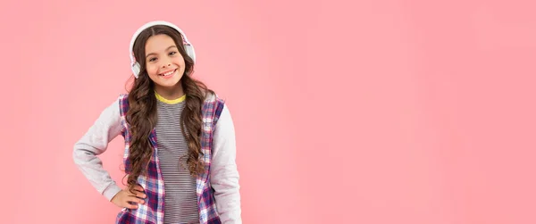 Niño sonriente escuchando música en auriculares sobre fondo rosa con espacio para copiar, la vida moderna —  Fotos de Stock