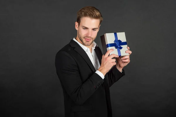 Hombre joven en traje mostrando caja de regalo de cumpleaños — Foto de Stock