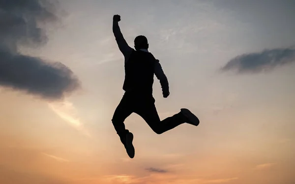 Человек прыгает высокий силуэт, полный энергии против заката неба, энергии — стоковое фото