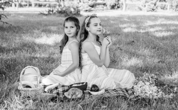 Piknik rodzinny. Małe dziewczynki jedzą piknik na zielonej trawie. Wakacje. Jedzenie na świeżym powietrzu. Ciesz się dniem ze smacznym jedzeniem — Zdjęcie stockowe