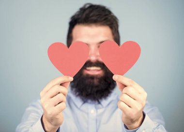 Bu aşktır. Seksi sevgililer günü erkeği gözlerini aşk kartlarıyla kapatıyor. Kırmızı kalp tutan sakallı adam. Küçük kalpli hippi. Sevgililer günün kutlu olsun. Aşkını ifade ediyor.