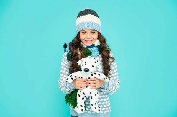 Vrolijk lachend kind in breigoed speeltje. tiener meisje op blauwe achtergrond. gelukkige jeugd. — Stockfoto