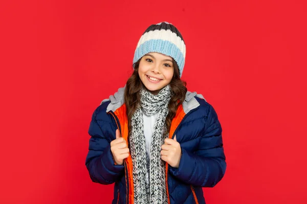 Alegre adolescente chica sobre fondo rojo. retrato de niño usando ropa de abrigo con bufanda. —  Fotos de Stock