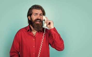 Tişörtlü, beyaz, vahşi hippi. Retro telefondan konuş, iletişim kur.