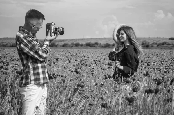 在罂粟地里，一对恋人在镜头前拍照，自然之美，令人赞叹的落日 — 图库照片