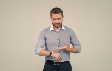 Tişörtlü yakışıklı, sakallı iş adamı, saati gösteriyor, vakit yok.