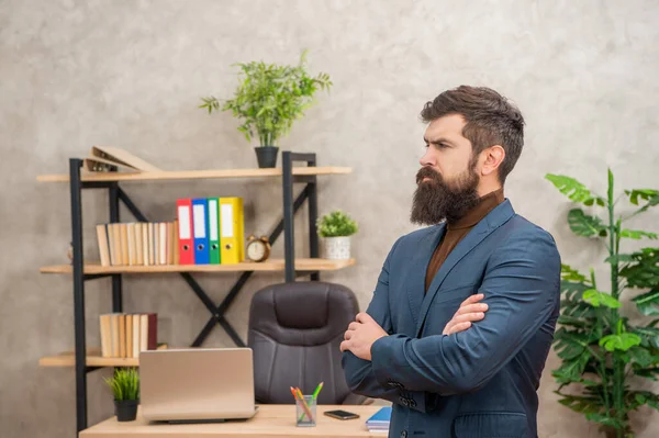 Başarılı, olgun, ceketli bir lider fotokopi alanı ve liderlikle ofiste duruyor.