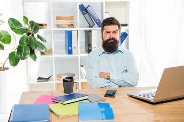 Sebevědomý skeptický obchodník se zkříženýma rukama sedí u kancelářského stolu, sebevědomí — Stock fotografie