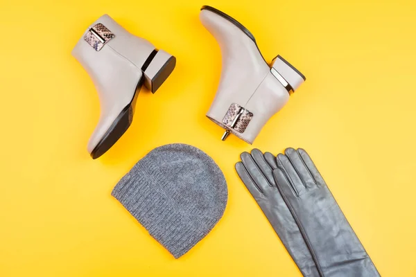 Стильные кожаные сапоги перчатки и шляпа на желтом фоне, модные аксессуары — стоковое фото
