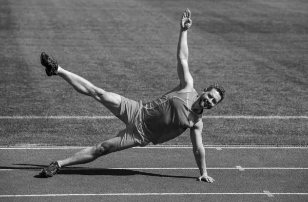 Μυώδης άνθρωπος σταθεί στο πλαϊνό σανίδα τέντωμα για την προπόνηση του αθλητισμού, πιλάτες — Φωτογραφία Αρχείου