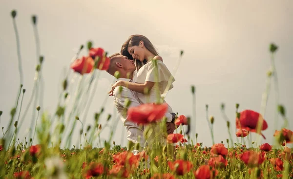 Gefühle ausdrücken. Mädchen und Mann auf dem Feld. Brautpaar. romantisches Paar mit roten Mohnblumen. Sommerurlaub für die Familie. Verliebte Männer und Frauen genießen das Frühlingswetter. Glückliche Beziehungen — Stockfoto