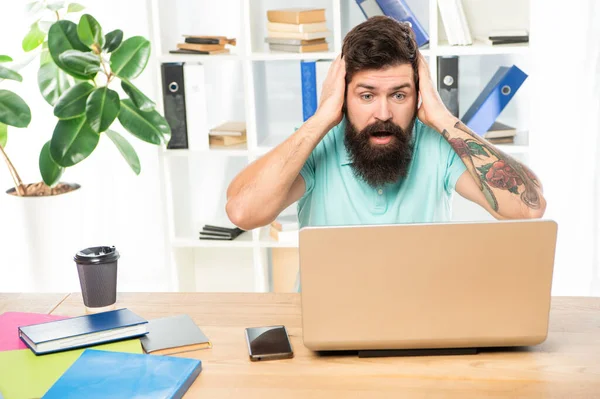 Chockad affärsman kramar huvudet stirrar i laptop på kontoret skrivbord, chock — Stockfoto